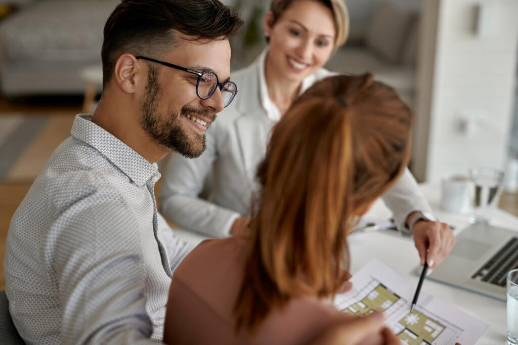 Conseiller présentant un projet immobilier à un couple souhaitant investir